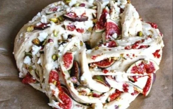 Hefekranz mit Feigen, Pistazien und Feta Käse auf einem Tisch dekoriert