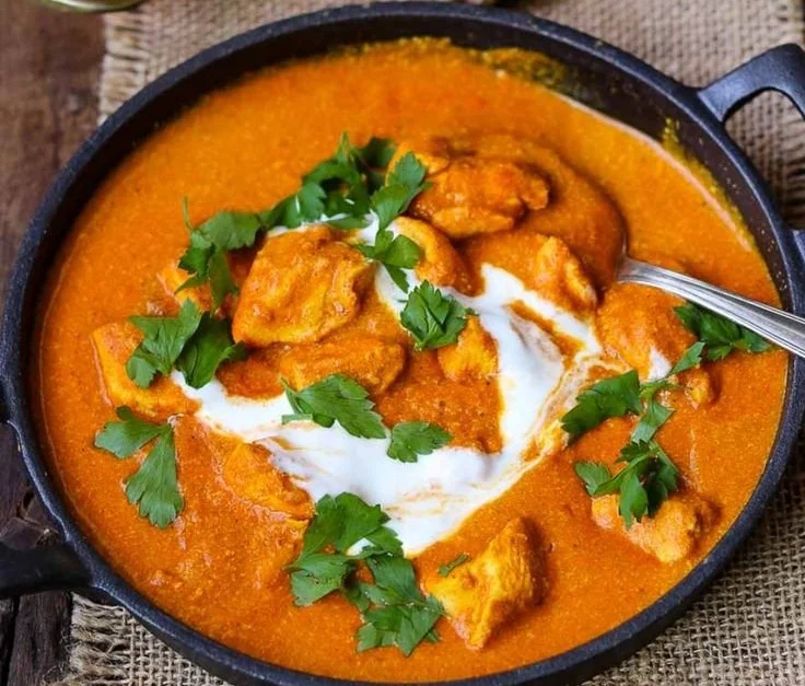 Delikates Butter Chicken Gericht auf einem Teller serviert mit Reis