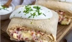 Leckeres Handbrot mit Schinken und Käse auf einem Holzbrett zum Servieren.