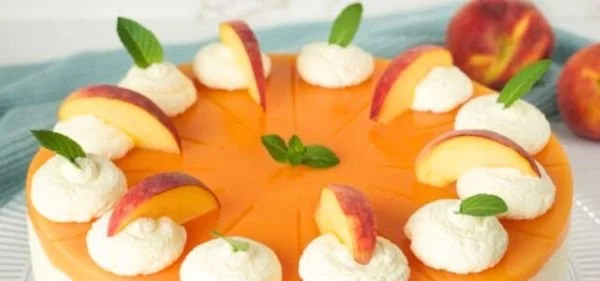 Pfirsich-Maracuja-Torte mit frischen Früchten und Sahne dekoriert
