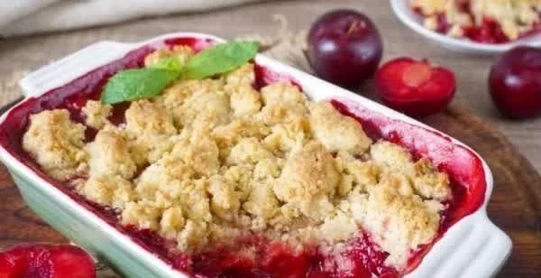 Leckeres Pflaumen-Crumble Dessert auf einem Teller serviert