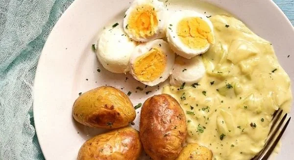 Senfeier mit Spitzkohl und Kartoffeln auf einem Teller