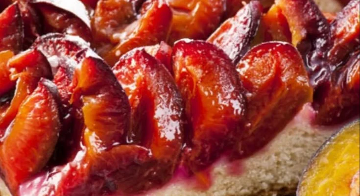 Leckerer Zwetschgenkuchen vom Blech auf einem Tisch serviert.